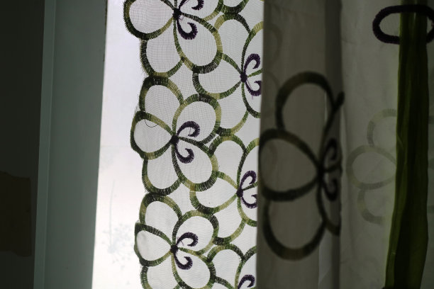 窗前有透明颜色和花卉图案的窗帘图片下载