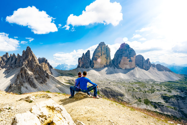 一对年轻的运动夫妇在下午欣赏帕特诺山和三山的美景。三琴，白云石，南蒂罗尔，意大利，欧洲。图片下载