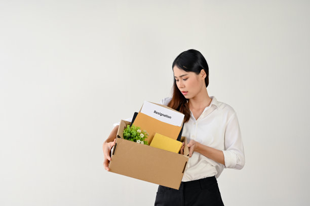 拿着纸箱和辞职信的悲伤亚洲女职员图片下载