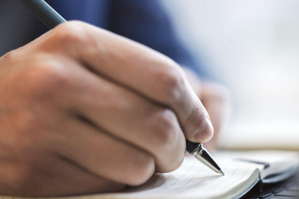 特写男性手写的记事本上模糊的背景图片下载