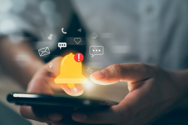 手动使用智能手机，显示铃声图标和应用程序上的新消息通知。图片下载