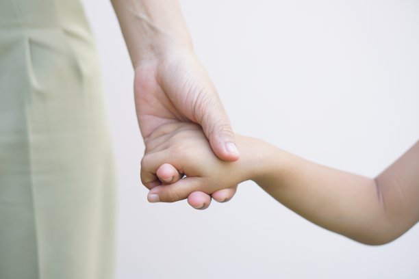 母亲和孩子手牵着手接受某样东西图片下载