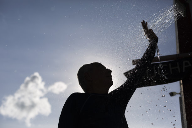一个人在日落时分在海滩上洗澡的剪影图片下载