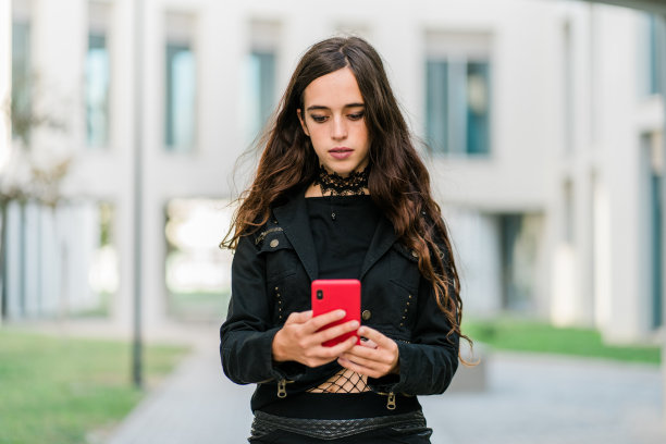 一个穿黑衣服的年轻女子在外面打电话图片下载