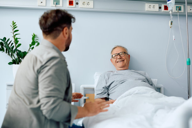 快乐的老人和来医院看望他的儿子谈话。图片下载