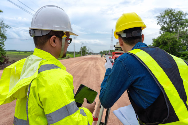 亚洲工程师手持平板电脑检查工作，工头使用望远镜、望远镜和无线电控制道路施工，背景是正在施工的道路图片下载