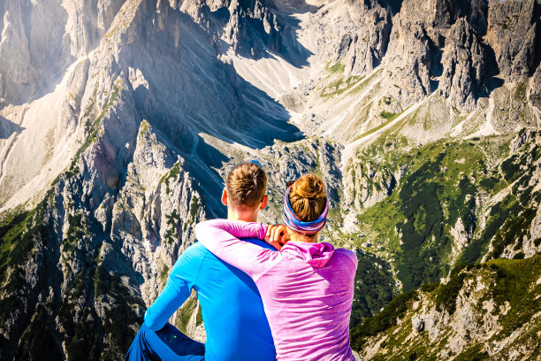 早晨，一对年轻夫妇坐着欣赏米苏里纳山脉的壮丽景色。三琴，白云石，南蒂罗尔，意大利，欧洲。图片下载