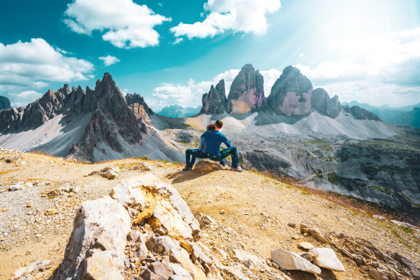 一对年轻的运动夫妇在下午欣赏帕特诺山和三山的美景。三琴，白云石，南蒂罗尔，意大利，欧洲。图片下载