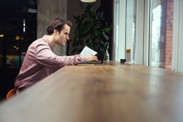 在咖啡馆用手提电脑工作的自由职业者图片下载