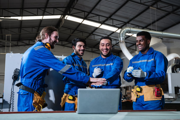 在车间里，团队木匠互相握手，以示成功。在家具厂手工制作家具。建筑工地概念。图片下载