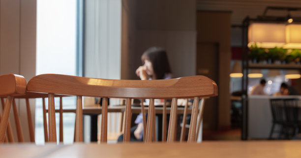 餐厅角落设有木质座椅，客人眺望窗外，选择性聚焦图片下载