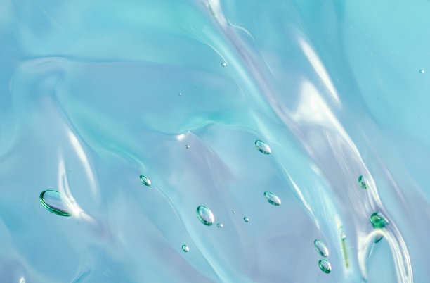 化妆品的凝胶质地。透明的奶油在蓝粉红色的背景与气泡。宏观照片。模糊和选择性对焦图片下载