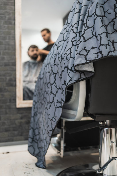 一个人在理发店剪头发时在镜子里的垂直影像。图片下载