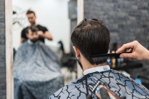 理发师在理发店里给顾客的后脑勺梳头。图片下载