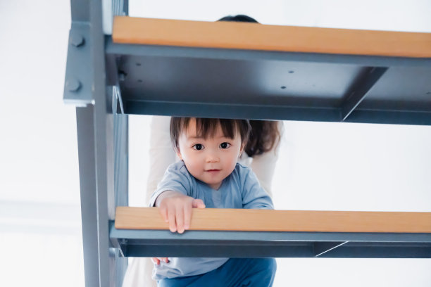 一个一岁的小男孩在家里爬上楼梯图片下载