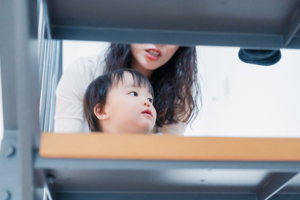 一个一岁的小男孩在家里爬上楼梯图片下载