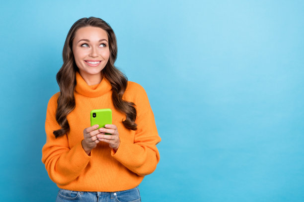 照片积极的千禧一代女士看空空间享受在线网络广告搜索设备孤立的蓝色背景图片下载