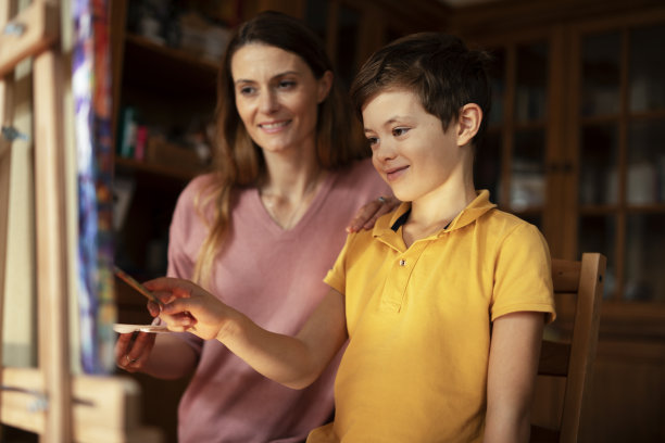 小男孩和妈妈在客厅画画。图片下载