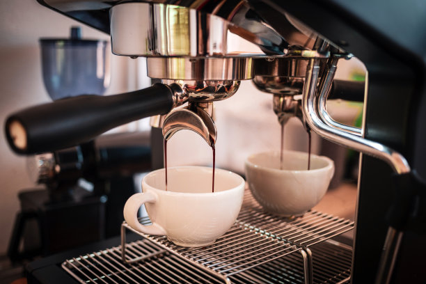 浓缩咖啡从一个专业的咖啡机与无底过滤器提取，特写从咖啡机的咖啡滴图片下载