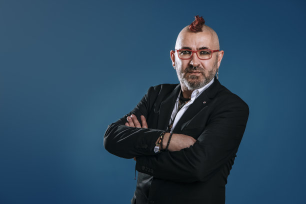 朋克风格的商人在工作室里双臂交叉，自信地看着相机图片下载