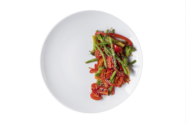 用芦笋、豆子、芝麻、西红柿、花椰菜、辣椒和胡萝卜做成的沙拉放在白色的盘子里图片下载