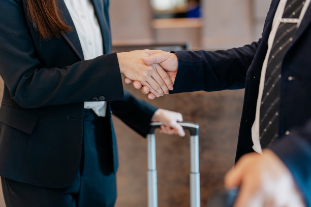 亚洲商业伙伴在酒店接待处握手图片下载