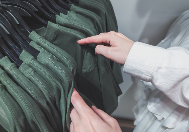 女士正在商店里挑选衣服和t恤。购物日和大减价。图片下载