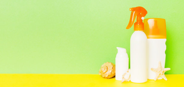 海滩配件。保湿防晒霜防晒乳液瓶为UVB护肤保护在夏天与贝壳彩色背景。模拟复制空间图片下载