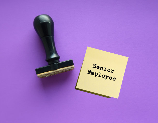 紫色背景上的橡皮图章上写着SENIOR EMPLOYEE，企业的理念是留住资深员工，以应对严重的员工短缺，并认识到老年员工的价值图片下载