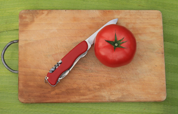 在准备烧烤的木板上用刀切西红柿图片下载