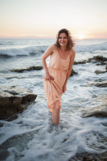 一个年轻的女人站在海边的街上图片下载