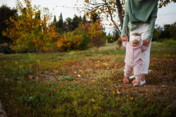一位母亲和她的女儿在秋天的公园散步图片下载