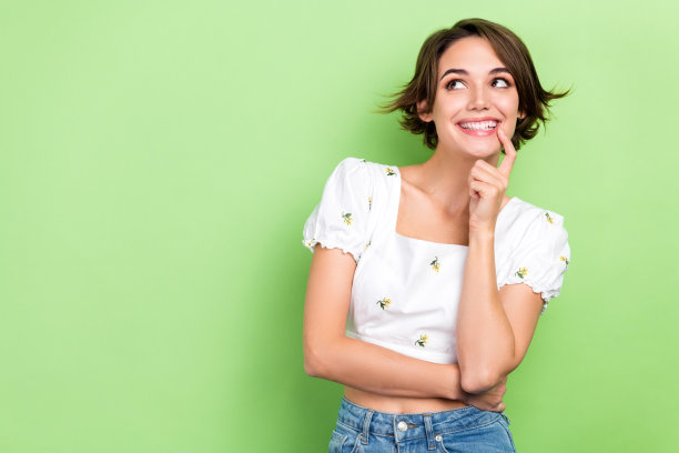 照片中闪亮梦幻的女人穿着白色的指尖嘴唇，看起来空白的空间孤立的绿色背景图片下载