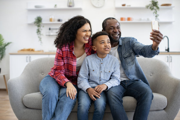 带着儿子的夫妇在家里的休息室上网打电话图片下载