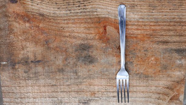 厨房工具。食物日:桌子上有一把银叉。一把闪亮的叉子，特写镜头。餐具在桌子上。餐具，特写镜头。桌上有银器。叉图片下载