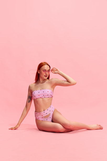 迷人的，年轻的，完美的，身材苗条的红发女孩的肖像，在粉红色的工作室背景下摆出美丽的泳衣图片下载