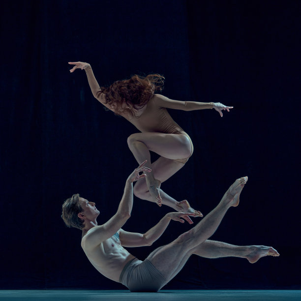美丽，艺术，年轻的夫妇，男人和女人在蓝色的工作室背景下跳芭蕾。令人印象深刻的艺术图片下载