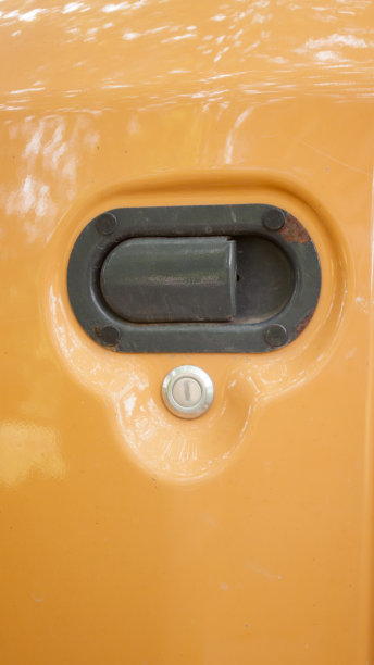 橙色工业机械的门把手图片下载