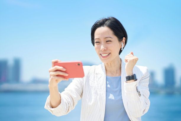 看着智能手机欢呼的女人图片下载