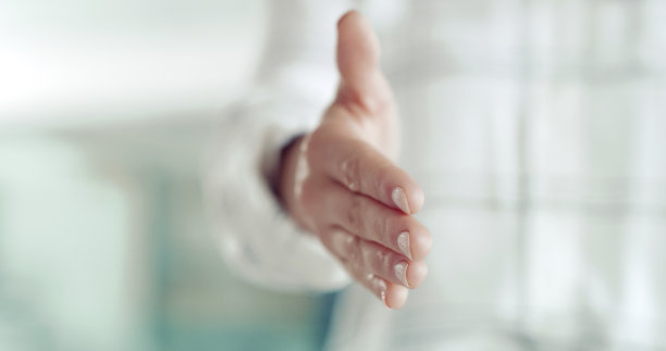 现代办公室里一位女商人伸手与人握手的特写镜头。女商人在面试中用欢迎的手势打招呼图片下载