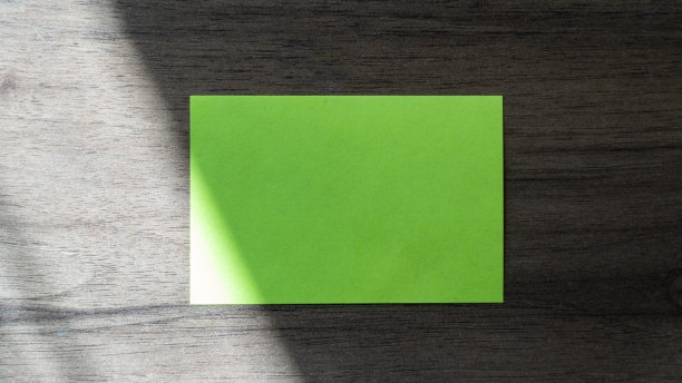 笔记本电脑，木桌上有空白便条和笔。空白贴在电脑上。文本复制空间Office desk高角度视图。图片下载