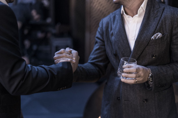 两位穿着时髦的男士正在握手合作图片下载