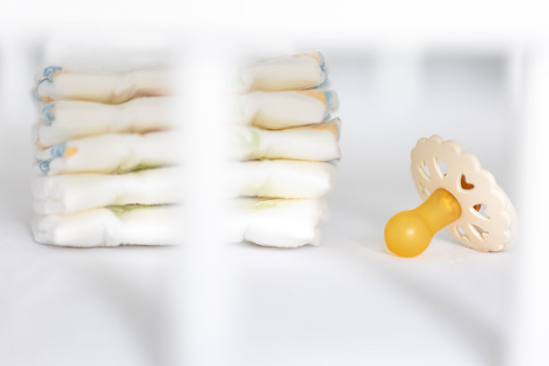 婴儿奶嘴在模糊的白色背景上。图片下载