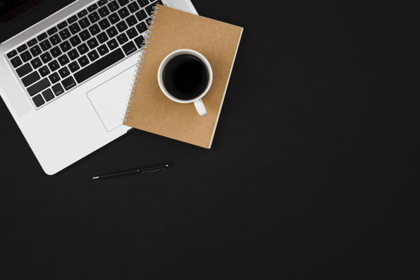 笔记本电脑，记事本和一杯咖啡在黑色背景孤立，俯视图。图片下载