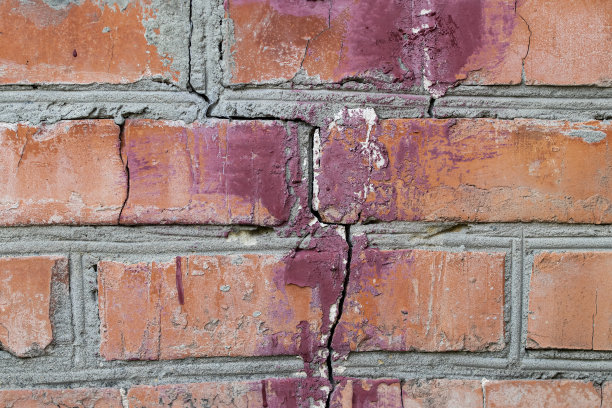 有大裂缝的砖墙。在建造房屋时违反技术的后果。图片下载