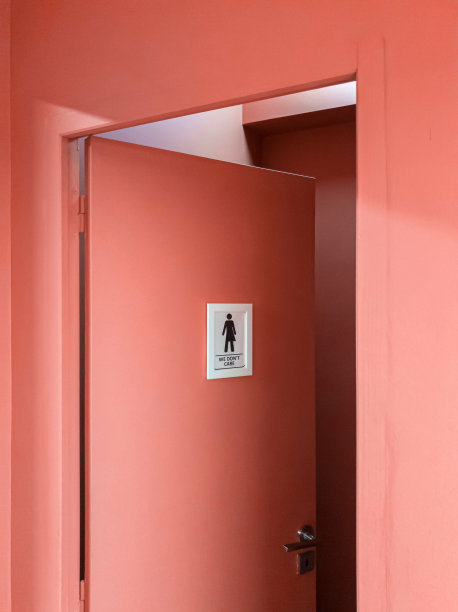 厕所入口，门上贴着乙烯基贴纸，上面写着“我们不在乎”。图片下载