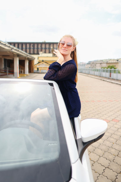 年轻成年女子坐在白色敞篷车里图片下载