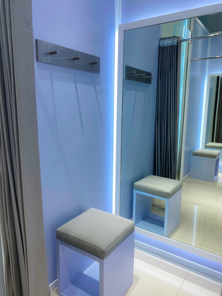 一排试衣间，里面有一面镜子和一把小椅子图片下载