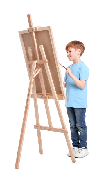 小男孩在白色背景下画画。使用画架来保持画布图片下载