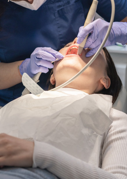 牙医清洁病人的口腔。图片下载